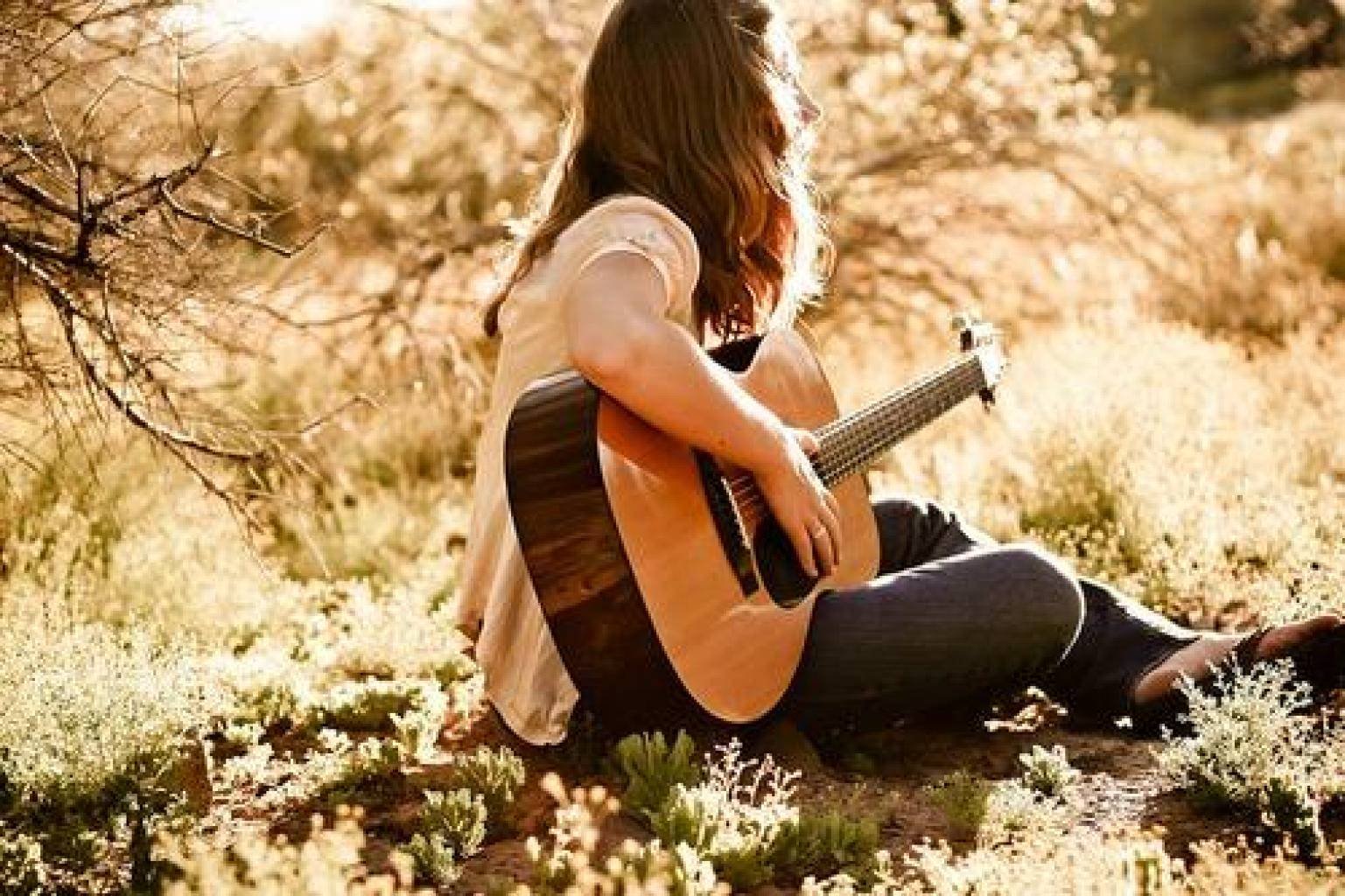 Красивая девушка красиво поет под гитару