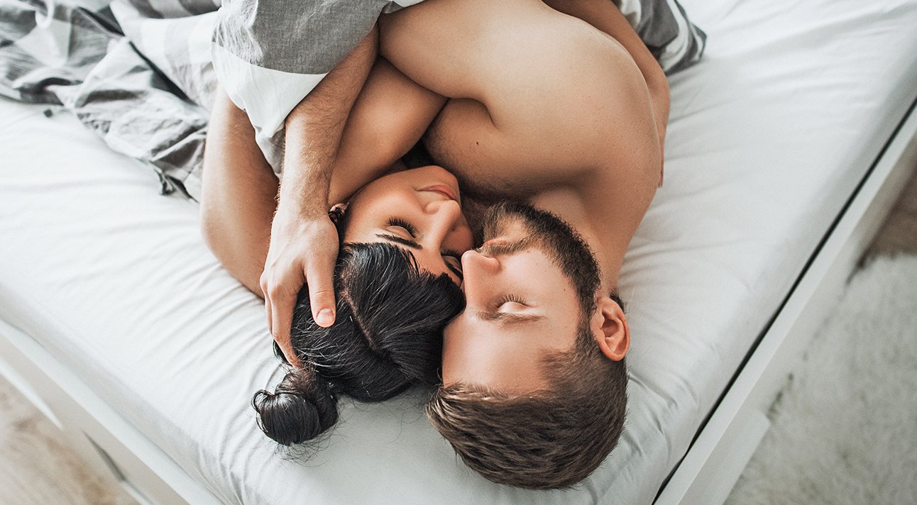 Молодая пара занимается сексом на кровати в спальне