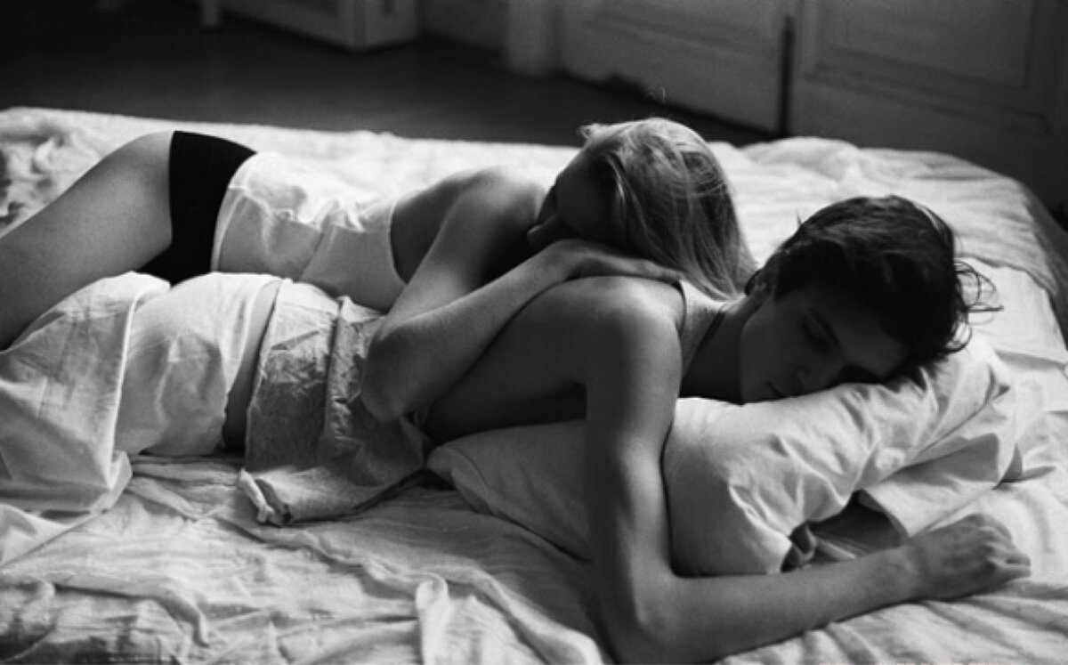 Молодая пара лежат и целуются в кровати