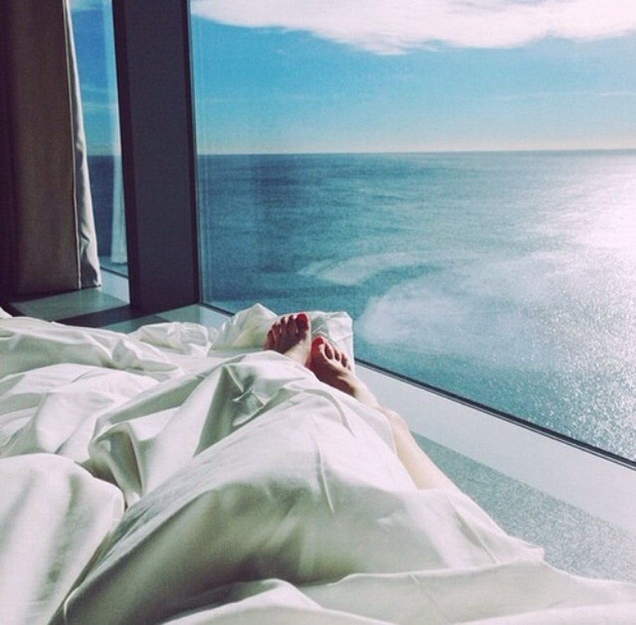 Кровать у окна с видом на море